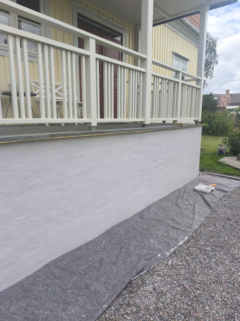 Krohvitud ja värvitud sokkel kollase voodrilaua all