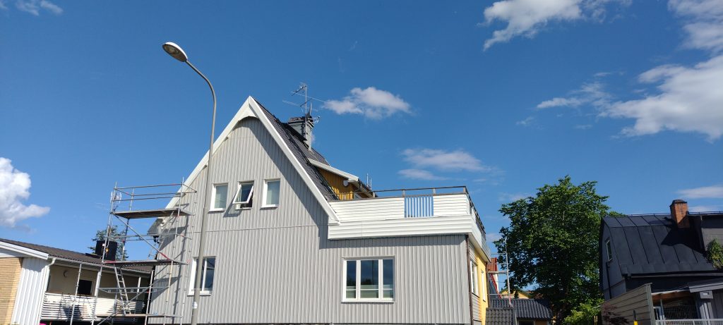 Tellingutega eramu tänavavaates, taustal naabermajad