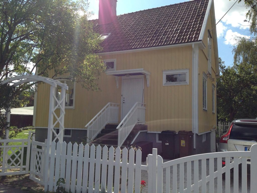 Kollane eramu, trepp ja valge piirdeaed pärast fassaaditöid