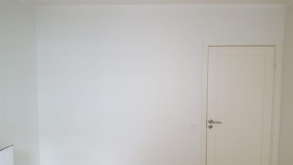 Sile pahteldatud ja värvitud sein koos valge uksega