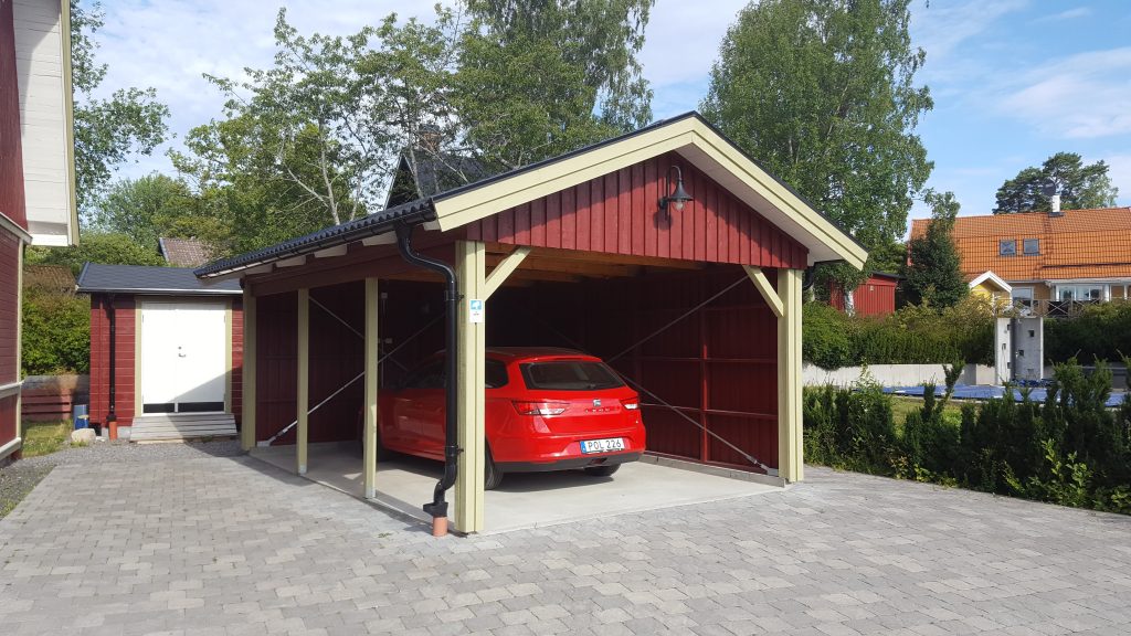 Punaseks värvitud autovarjualune ja auto kivisillutisel