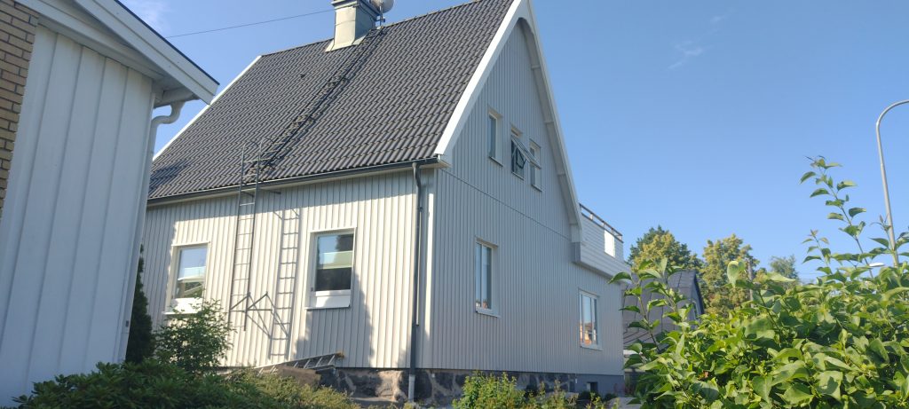 Valge voodrilauaga eramu ja katusele ulatuv redel