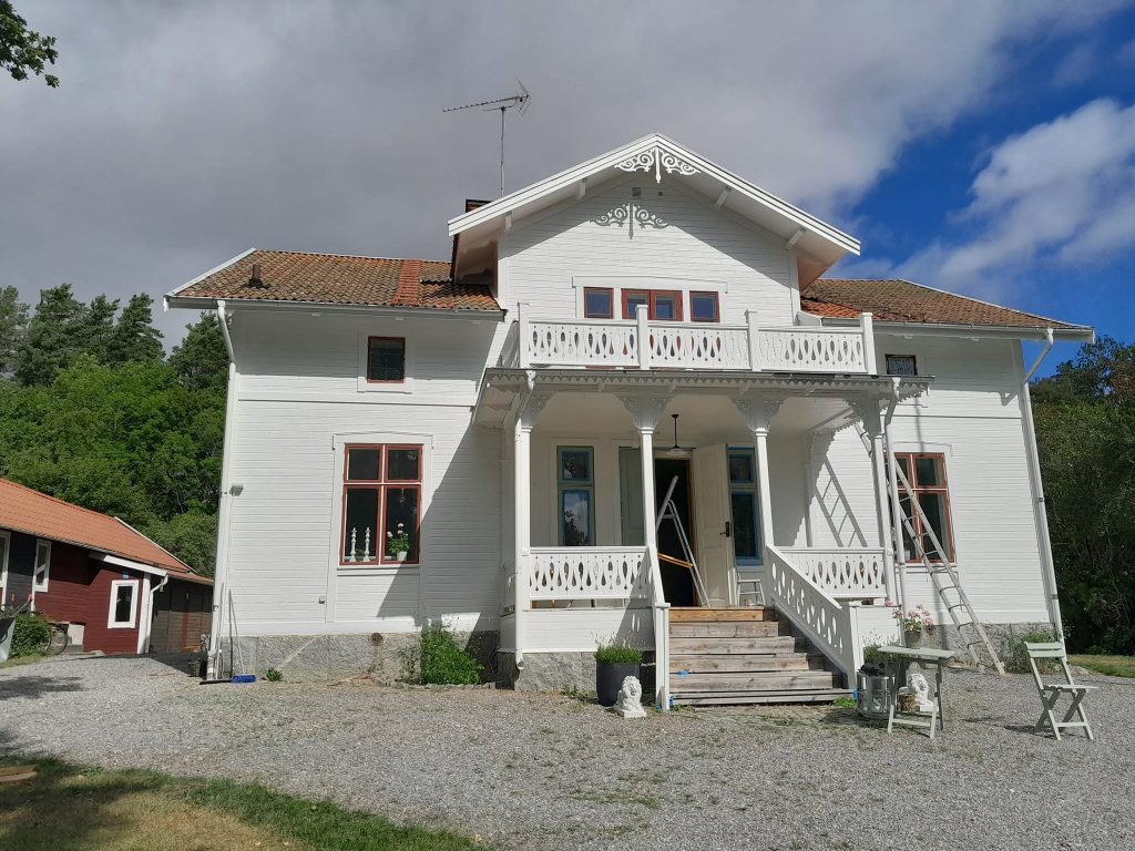 Valge villa esifassaad, veranda ja redel tööde ajal